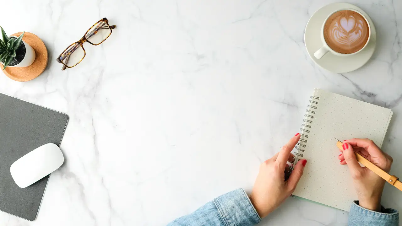 Uma mesa organizada com caderno, caneta e notebook com poucos apps, em um ambiente clean com tons neutros.