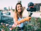 Uma microinfluenciadora de jardinagem a sorrir para a câmera enquanto grava um vídeo sobre plantas.