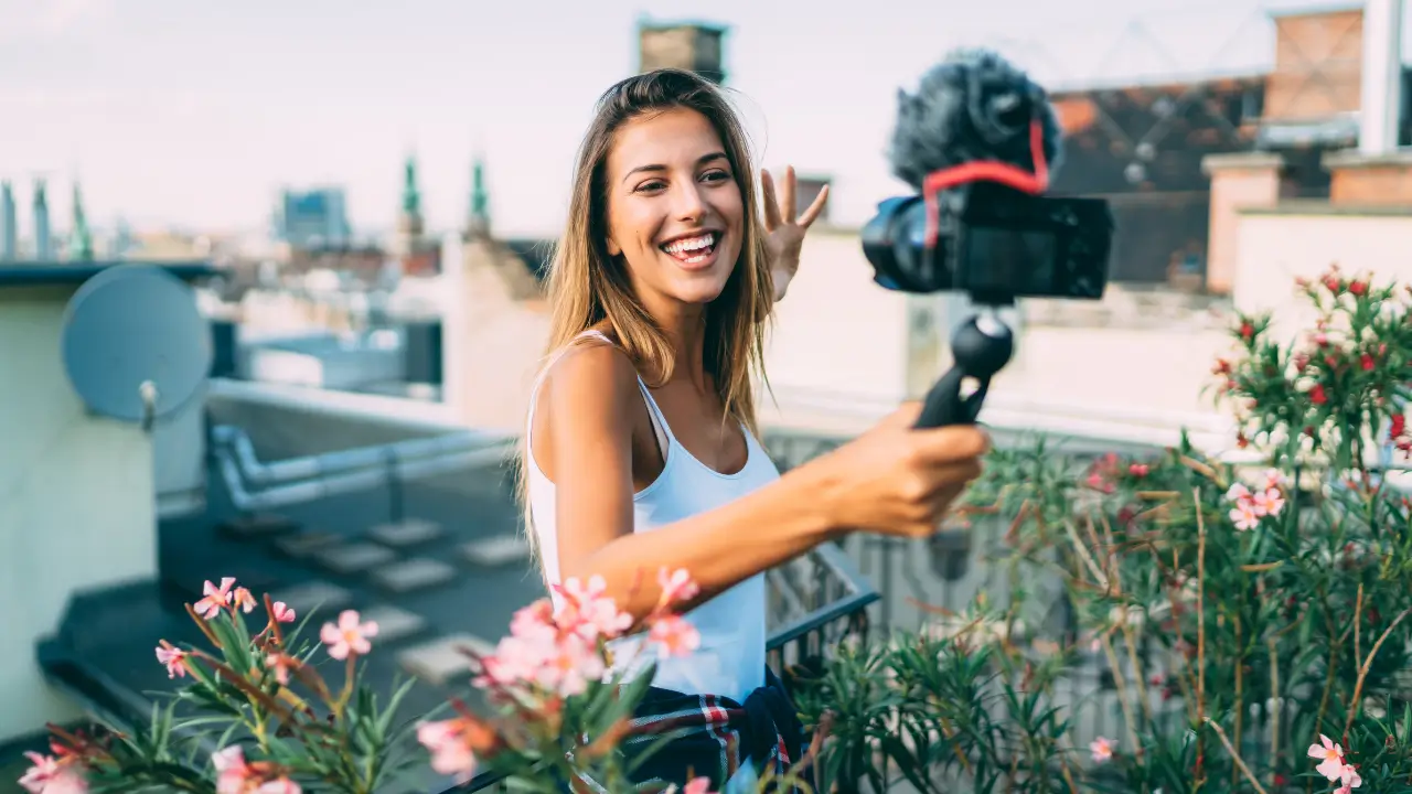 Uma microinfluenciadora de jardinagem a sorrir para a câmera enquanto grava um vídeo sobre plantas.